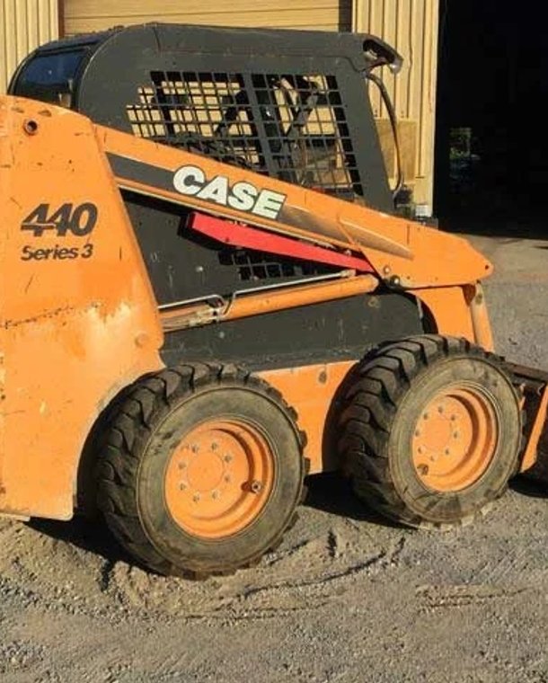 Front view of compact orange skid steer loader
